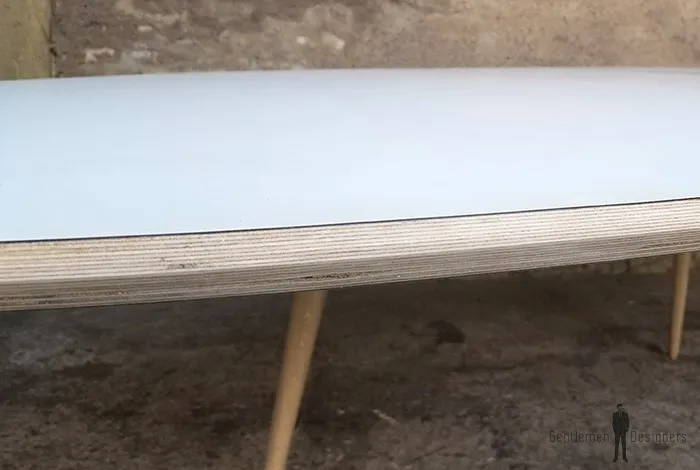 Table ovale avec un piétement en chêne massif local et un plateau blanc